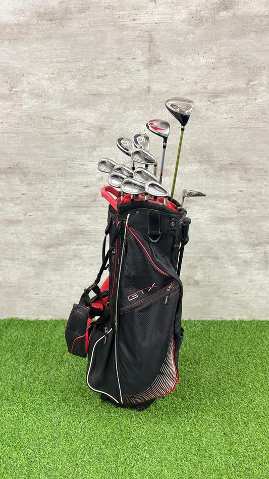 Golf clubs in a black bag on a green and gray background
