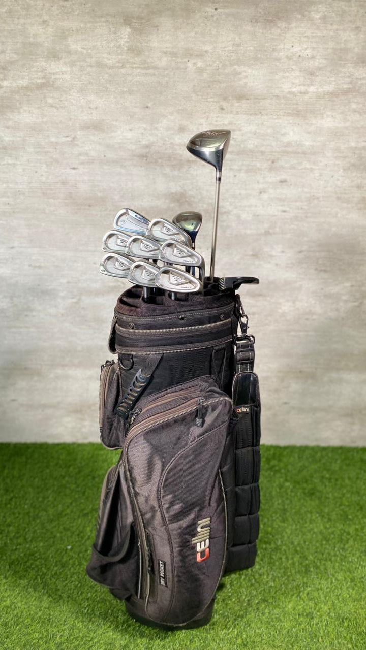 Golf bag with clubs on a green surface and gray background