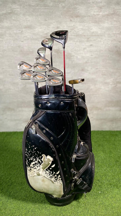 Black golf bag with golf clubs on a green surface and gray background