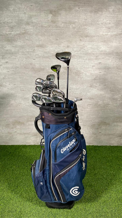 Blue golf bag with golf clubs against a gray wall