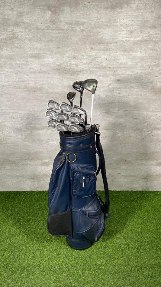 Navy blue golf bag with golf clubs on a green and gray background