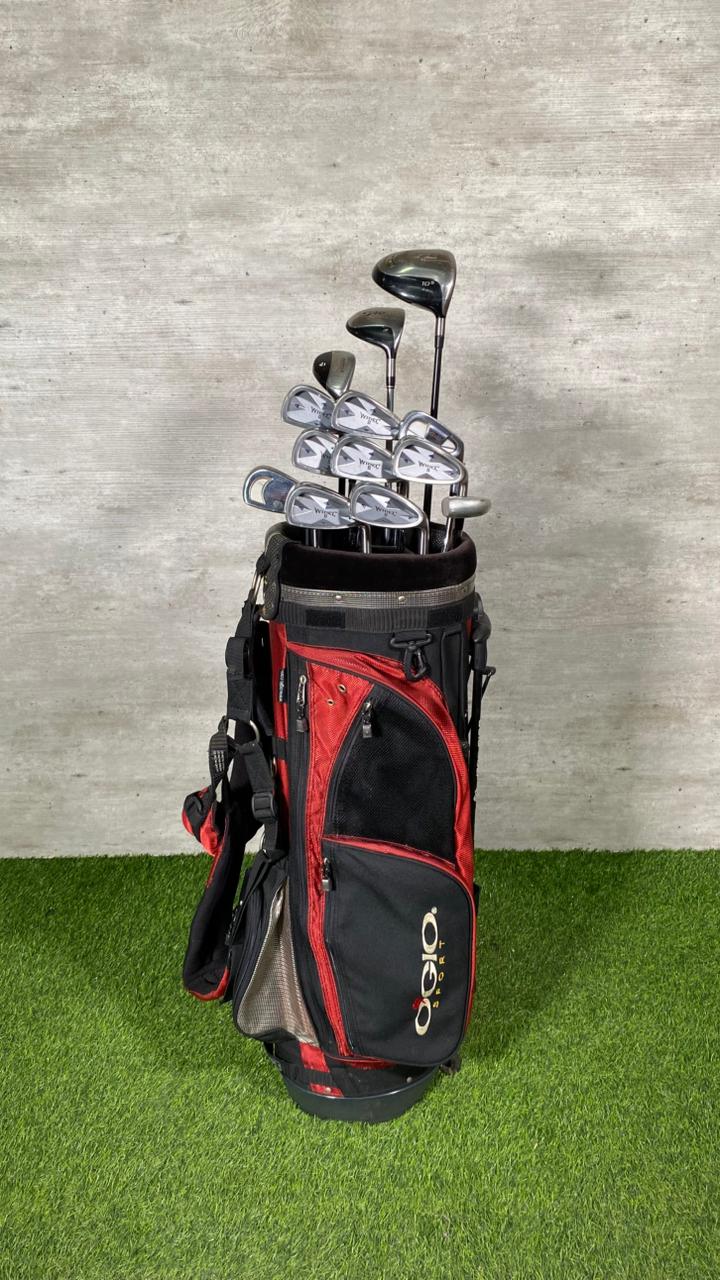 Golf clubs in a red and black bag on a green surface with a gray background