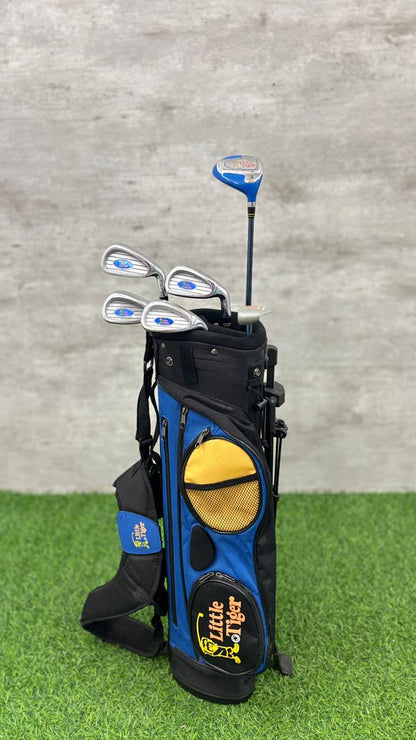 Golf club set with blue and black bag on green grass