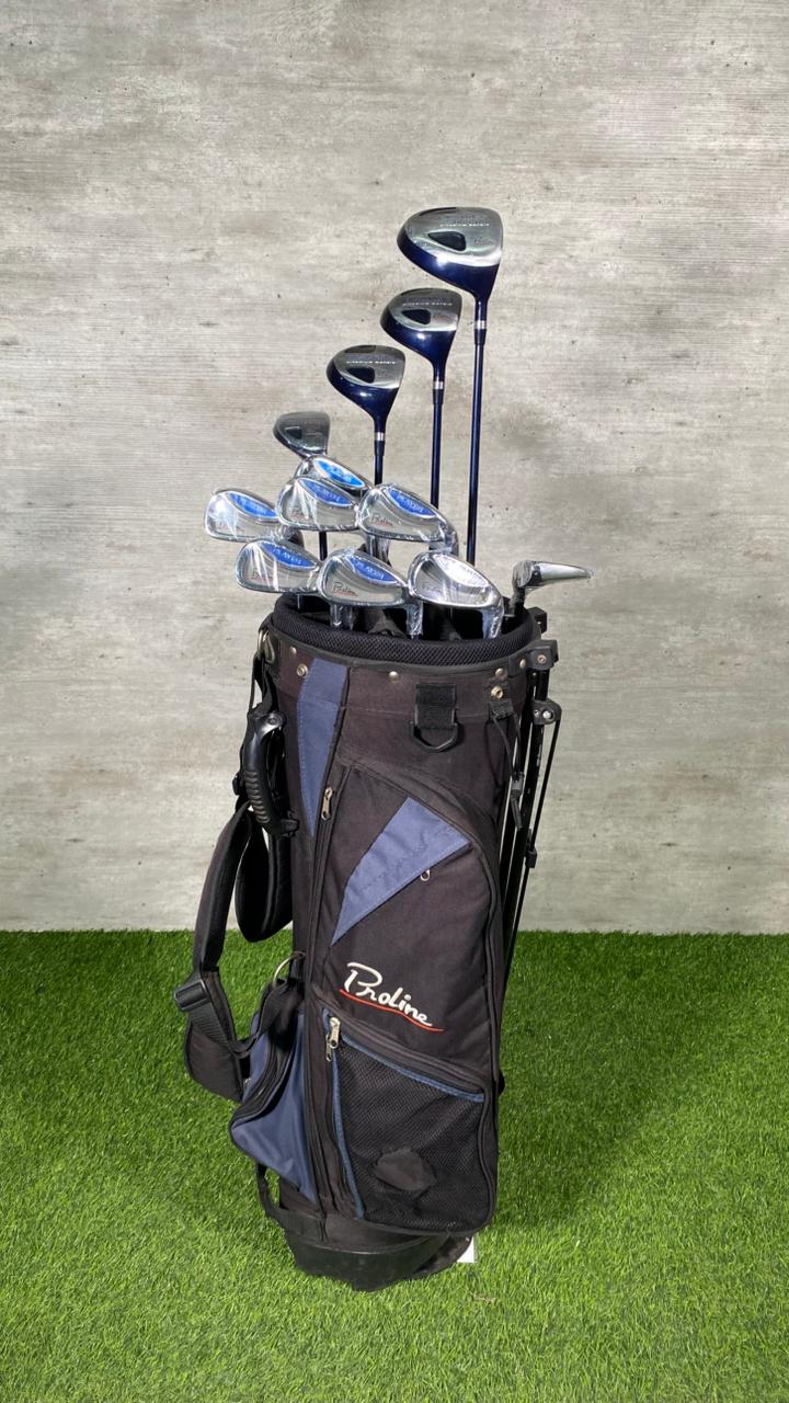 Golf clubs in a bag on grass with a concrete wall background