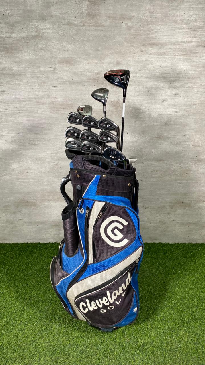 Golf clubs in a Cleveland golf bag on a grass and concrete background