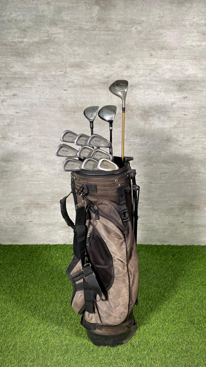 Golf clubs in a brown bag on a green grass and gray concrete background