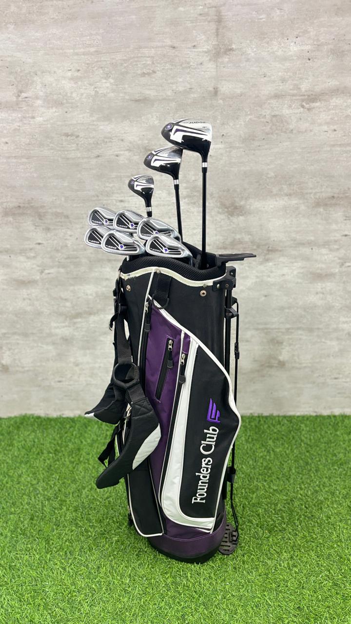 Golf club set with a black and purple bag on a green surface and gray background