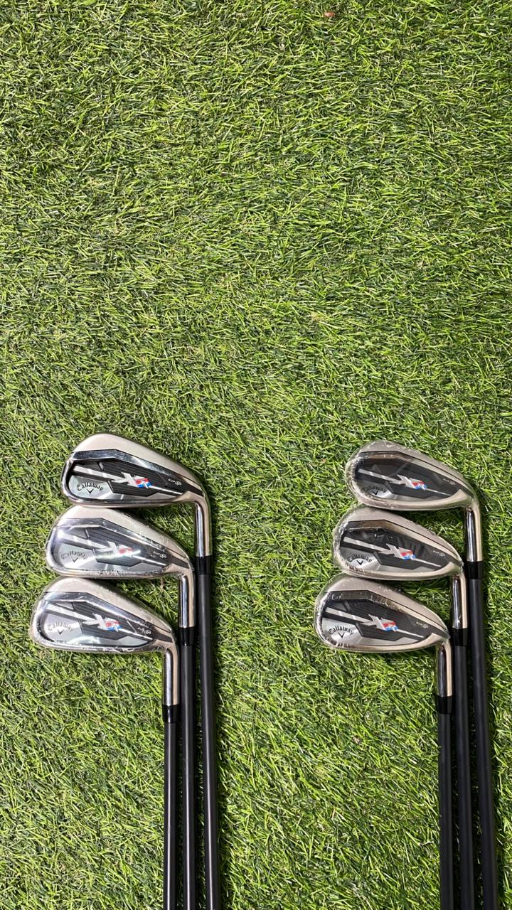 Two sets of golf clubs on a grassy background