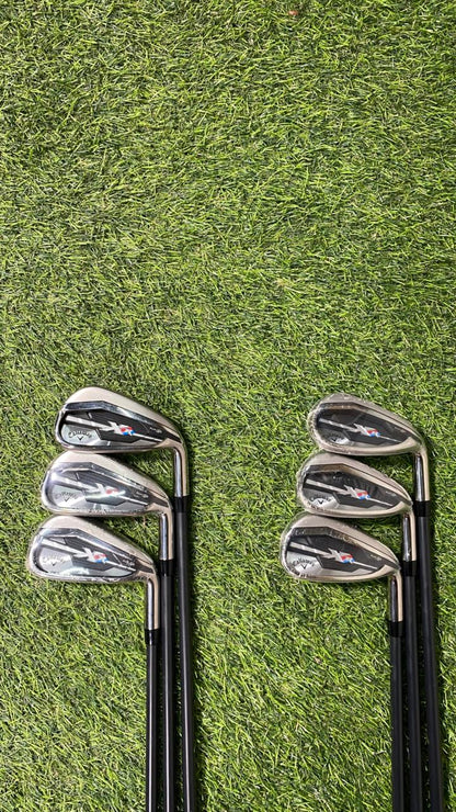 Two sets of golf clubs on a grassy background