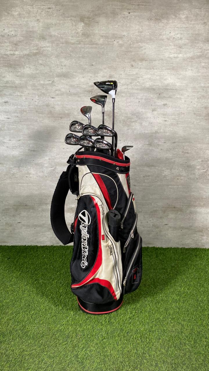 Golf bag with golf clubs on a green surface and gray background