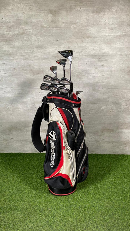 Golf bag with golf clubs on a green surface and gray background