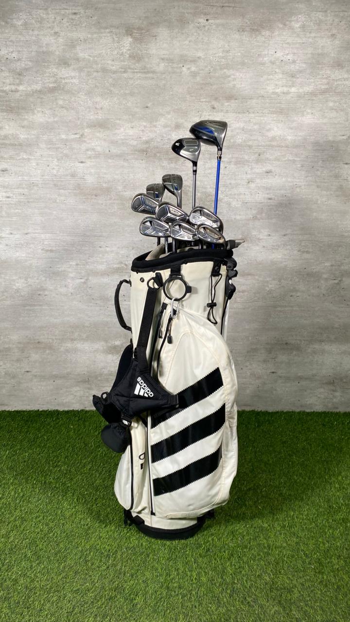 Golf bag with clubs against a gray wall
