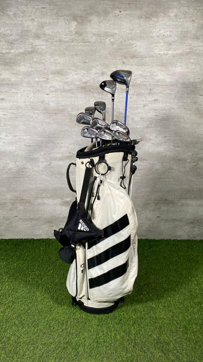 Golf bag with clubs against a gray wall