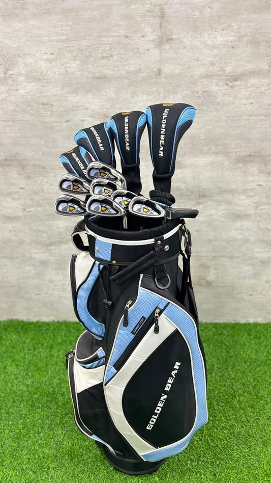 Golf club set with blue and black clubs in a black and blue bag on grass.