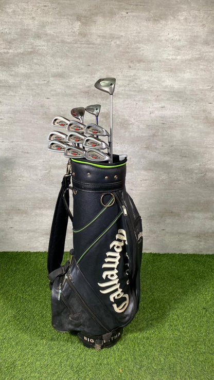 Callaway golf bag with golf clubs on a grassy surface and concrete wall background