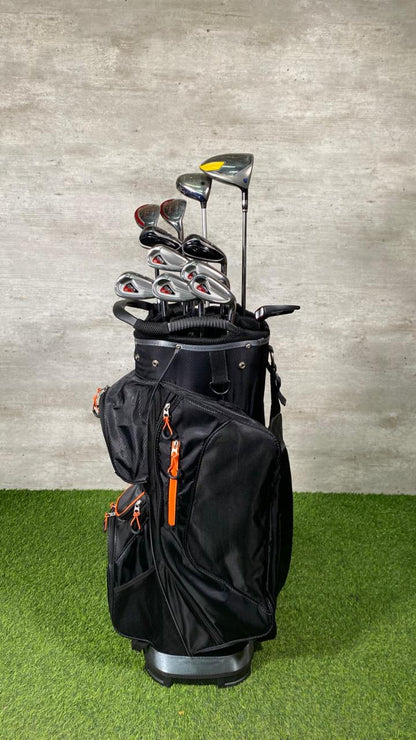 Black golf bag with golf clubs against a gray wall
