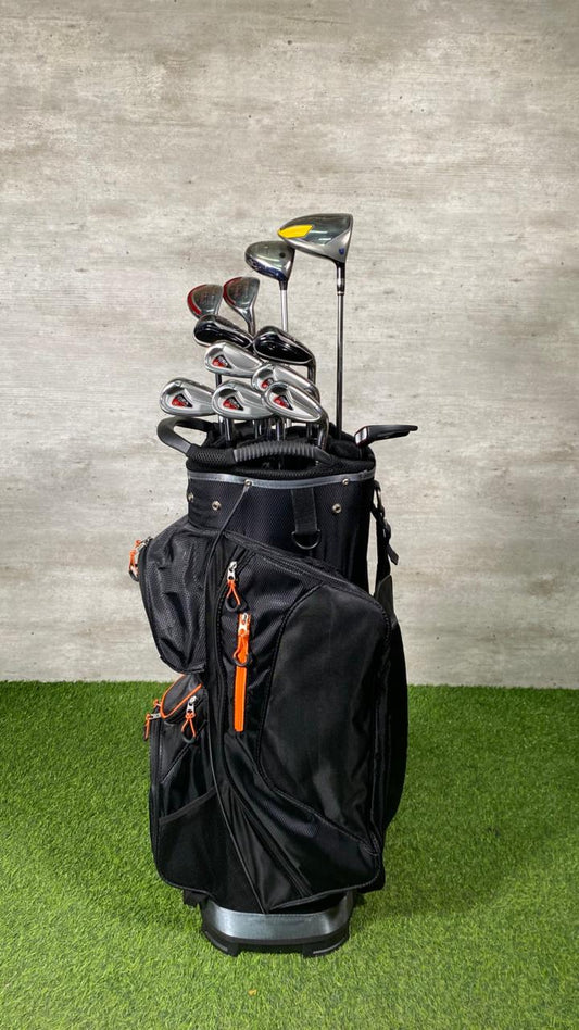 Black golf bag with golf clubs against a gray wall