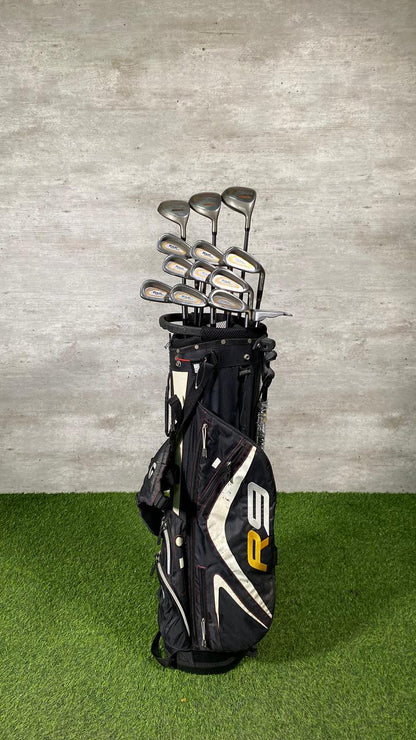 Golf clubs in a black bag on a green and gray background