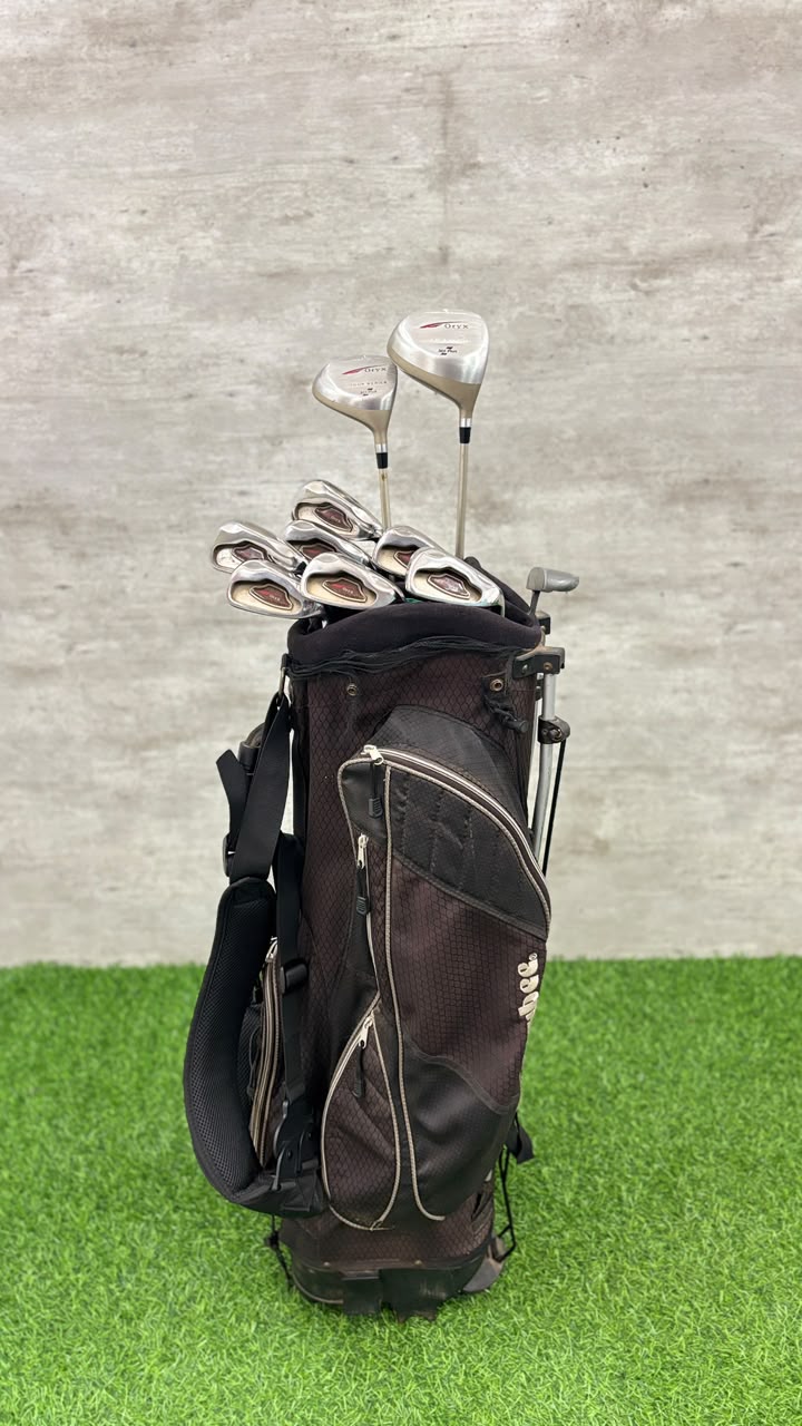 Golf clubs in a black bag on a green and gray background