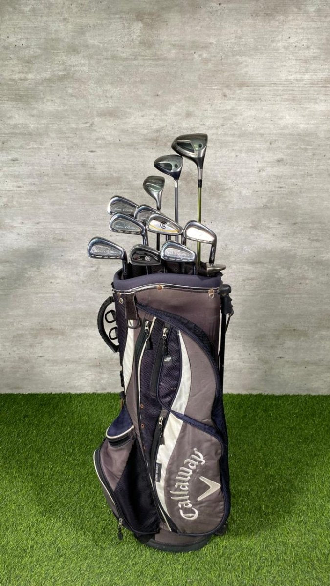 Callaway golf bag with golf clubs on a grassy surface and concrete wall background