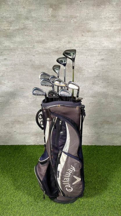 Callaway golf bag with golf clubs on a grassy surface and concrete wall background