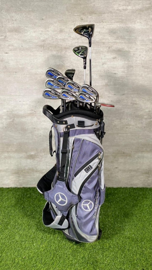 Golf bag with clubs on a green surface and gray wall background
