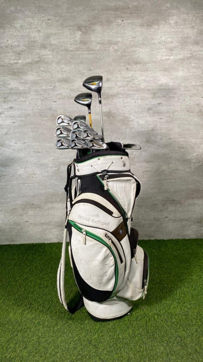 Golf bag with clubs on a green surface and gray background