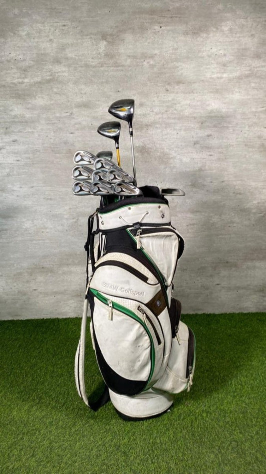 Golf bag with clubs on a green surface and gray background