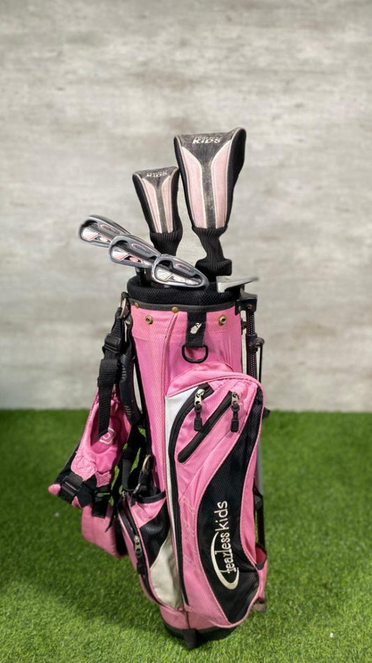 Pink golf bag with clubs on a grassy surface