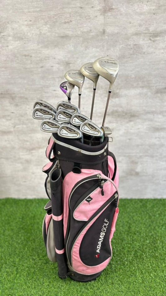 Pink and black golf bag with golf clubs on a grass and concrete background