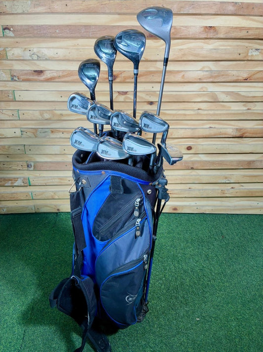 Set of golf clubs in a blue and black bag against a wooden wall.