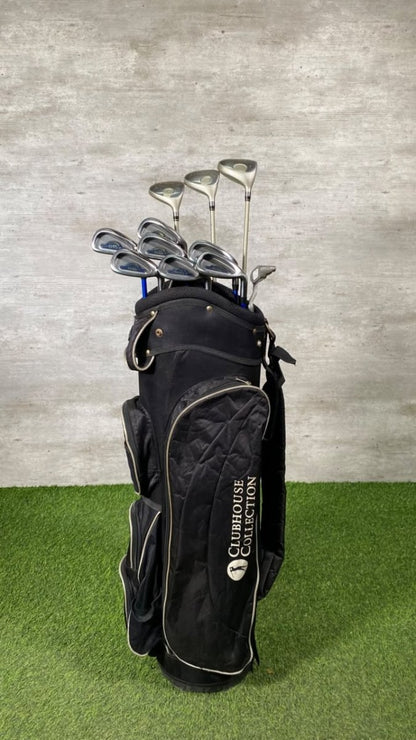 A black Clubhouse Collection golf bag filled with golf clubs, standing on artificial green turf against a gray textured wall.