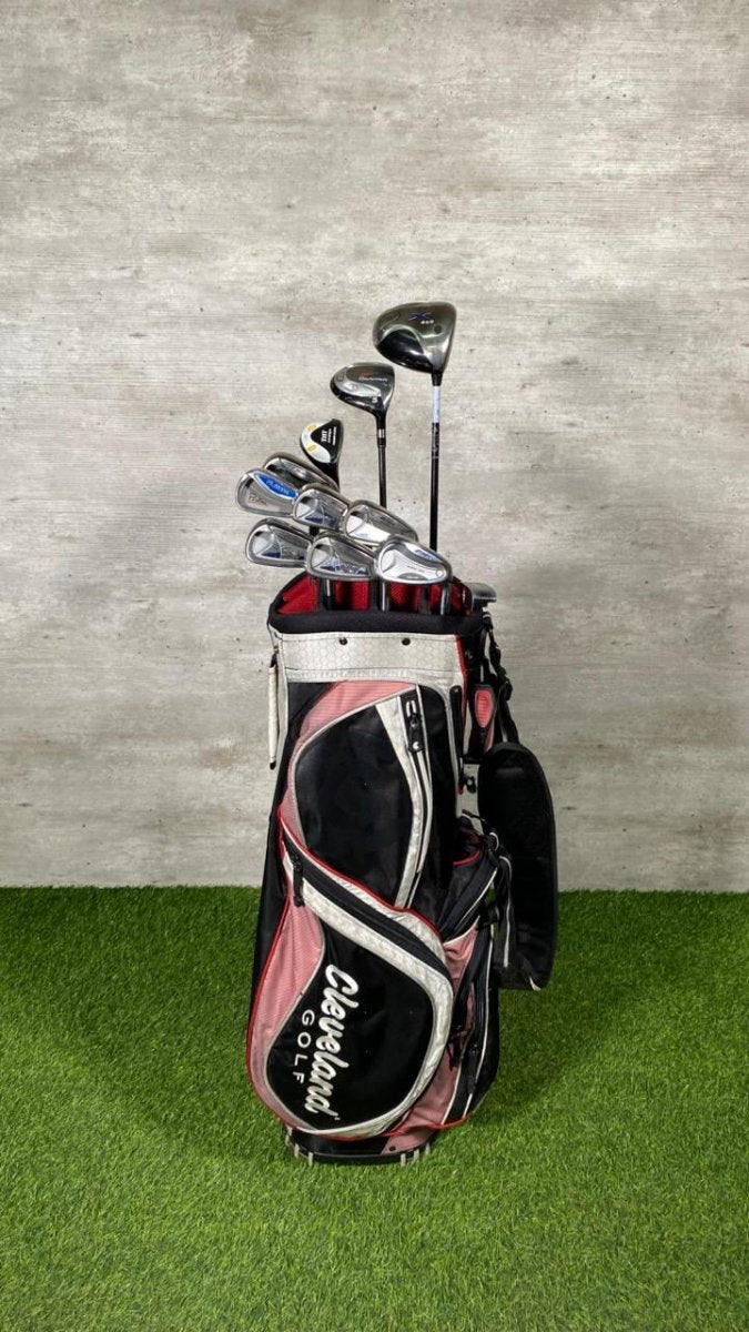 Golf clubs in a bag on a green surface with a gray background