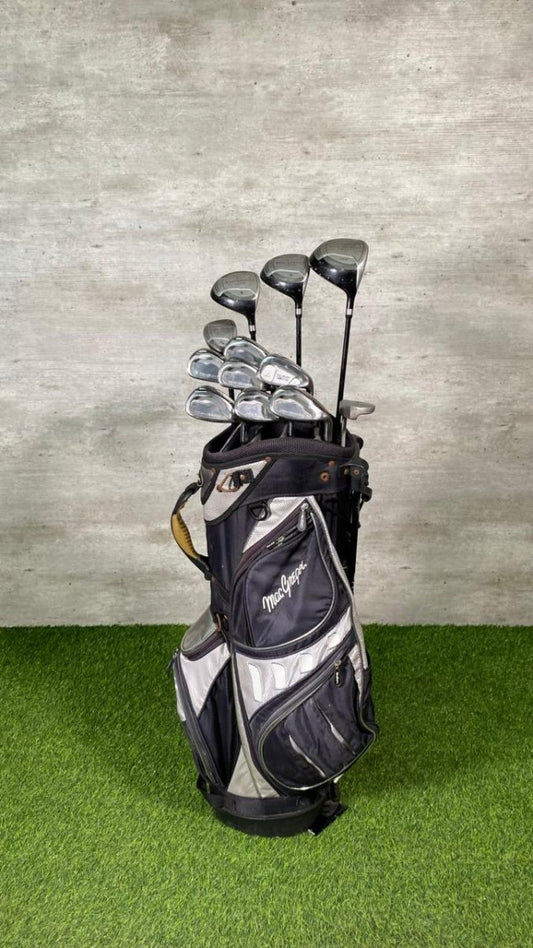 Golf clubs in a bag on a green surface with a gray textured wall background