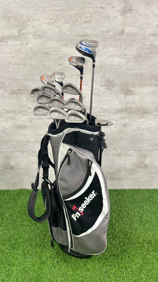 Golf club set in a bag on grass with a concrete wall background