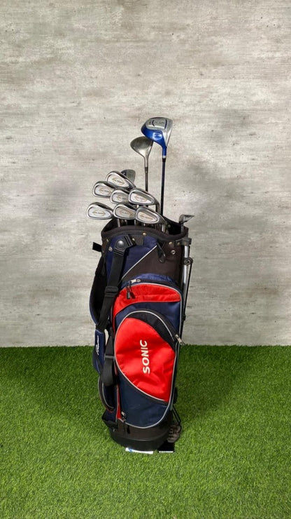 Golf club set in a blue and red bag on a green surface with a gray background