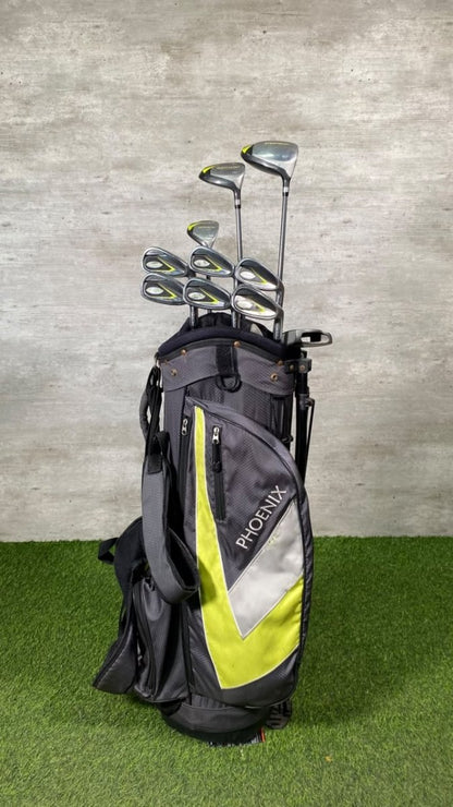 A Phoenix brand golf bag filled with golf clubs, standing on artificial green turf against a textured gray wall.
