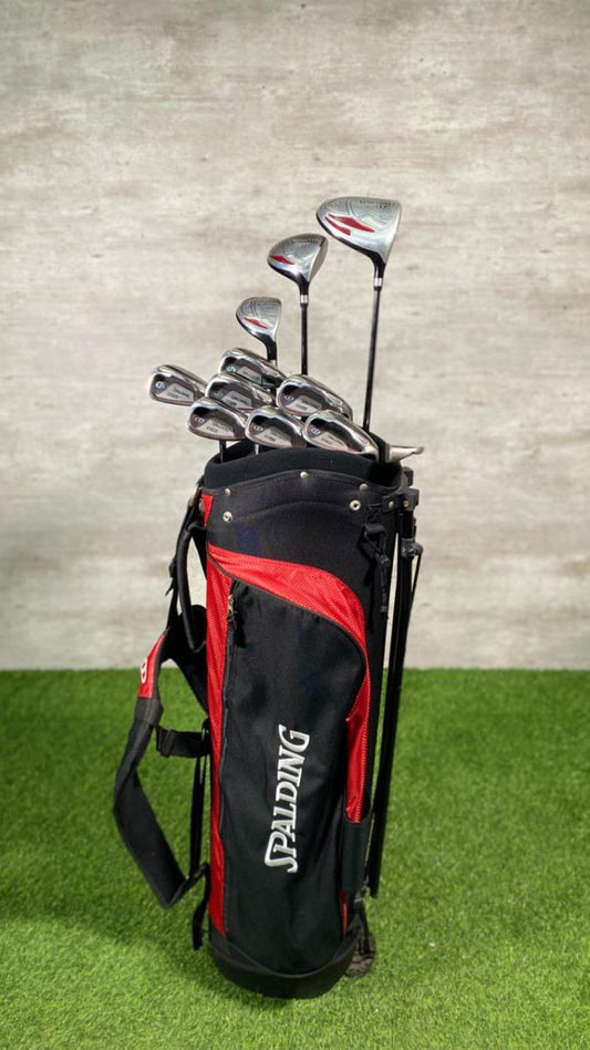 Spalding golf bag with golf clubs on a green surface and gray background