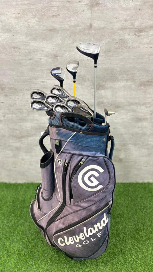 Golf bag with clubs on a grass and concrete background
