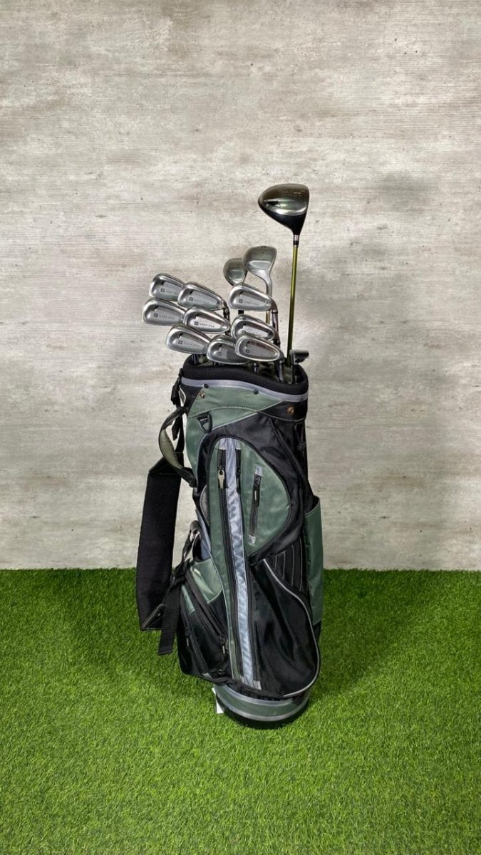 Golf clubs in a black bag on a green surface with a gray textured wall background
