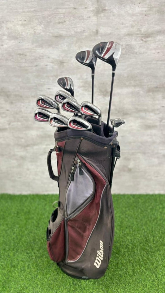 Golf clubs in a black bag on a grass and concrete background