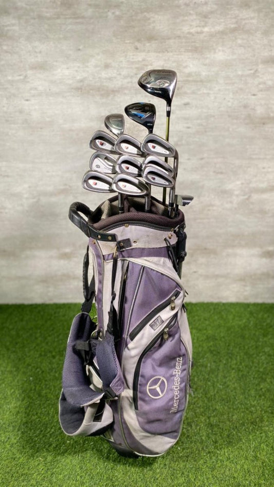 Golf bag with clubs on a green surface and gray wall background